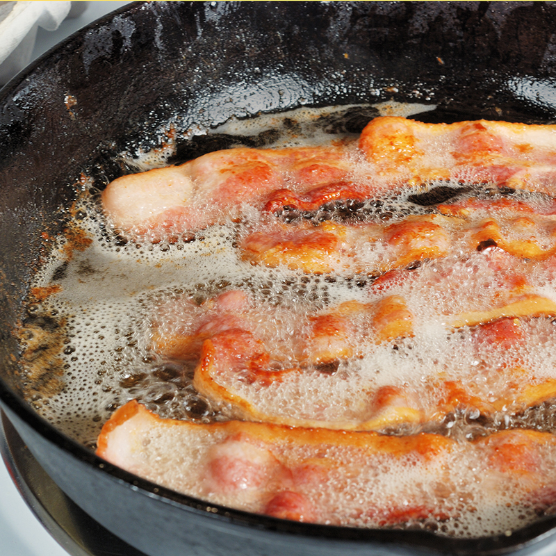 Bacon frying in cast iron pan